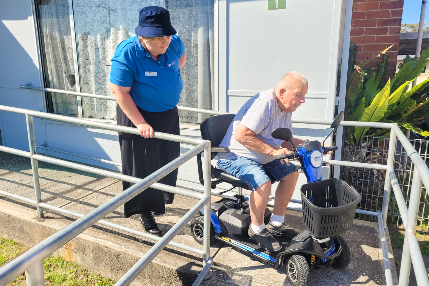 Occupational Therapist supporting a client to navigate a ramp with their scooter