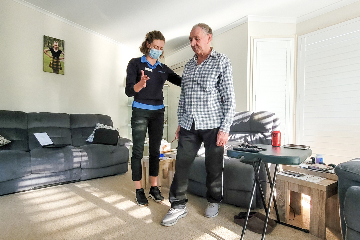 Physiotherapist supporting a Home Care client with balance exercises