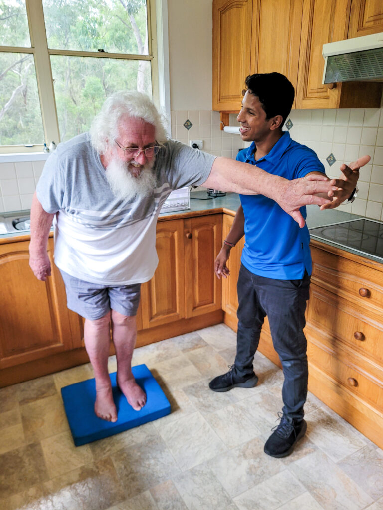 Physiotherapist and aged care client doing balance exercises for falls prevention